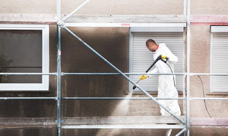 Limpieza de la fachada de un edificio encima de un andamio